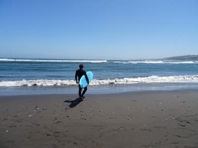 Surfer mit Surfboard in Chile.