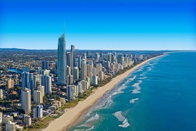 Küstenlinie der Gold Coast mit leuchtend blauem Meer und der Skyline der Stadt.