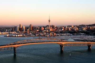 Blick auf Skyline und Hafen von Auckland bei Sonnenuntergang