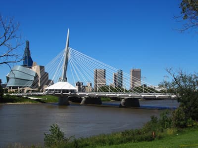 Moderne Brücke vor einer Skyline am Fluss