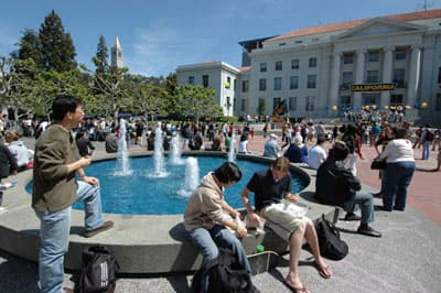 Studenten sitzen am Brunnen auf dem Campus