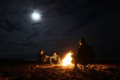 Marvin und seine Freunde sitzen um ein Lagerfeuer am Strand