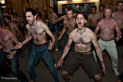 Eine große Gruppe junger Männer mit entblößten Oberkörpern während eines Hakas
