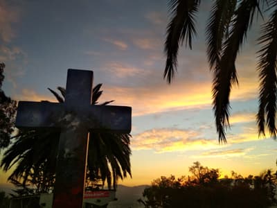 Buntes Kreuz und Palmen auf dem Cerro San Cristobal in Santiago