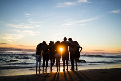 Studenten beobachten den Sonnenuntergang am Strand