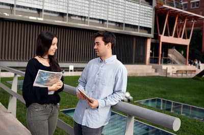 Zwei Studenten unterhalten sich vor dem Managementgebäude des IQS