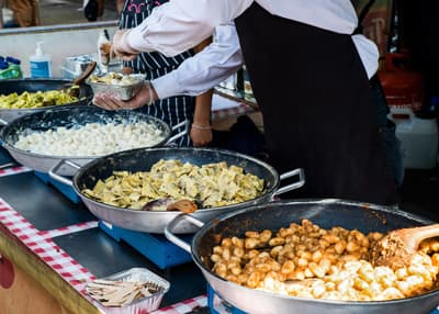 Mehrere Pfannen mit Essen in einem Essensstand