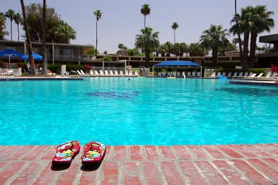 Ein Pool in einer Freizeitanlage mit Flipflops am Beckenrand