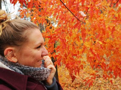 Alexandra vor leuchtend orangenen Blättern des kanadischen Indian Summers
