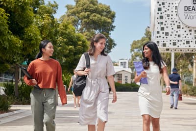 3 Studentinnen laufen über den Burwood Campus