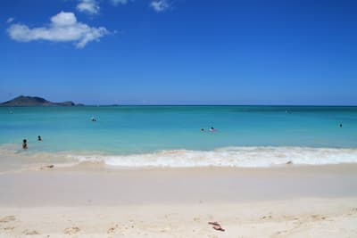 Strand mit weißem Sand und leuchtend türkisem Wasser auf Oahu