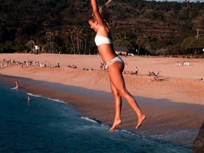Studentin springt von einer Klippe ins Meer