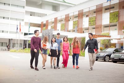 Studierende vercshiedener Herkunft laufen gemeinsam über den Campus der Uni.