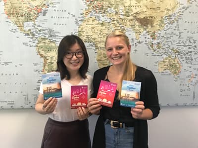Shelley Wang von der JCU und CoCo-Asien-Expertin Stephanie mit Flyern der Better Together-Kampagne