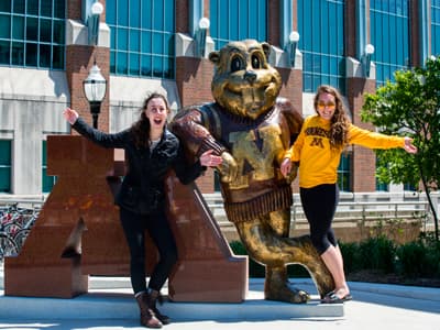 Studentinnen mit dem Maskottchen der University of Minnesota