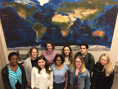 Studierende des Global College vor einer großen Weltkarte.