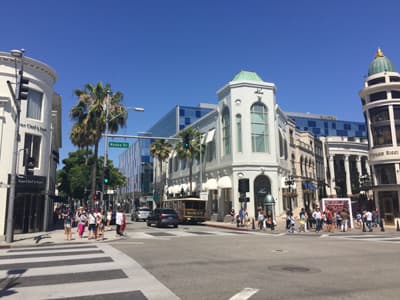 Straßenkreuzung mit prunkvollen Geschäftsgebäuden am Rodeo Drive in Beverly Hills