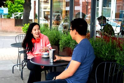 Studierende der Uni in einem Straßencafé