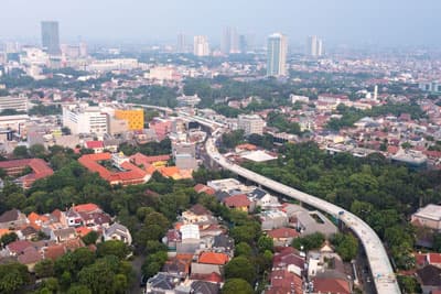 Luftaufnahme von einer Stadt mit vereinzelten Hochhäusern
