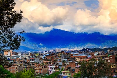 Blick auf die von umwölkten Bergen umringte Stadt Kathmandu