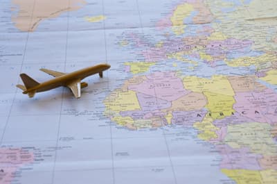 Miniaturflugzeug auf einer Weltkarte mit dem Ausschnitt Afrika und Europa