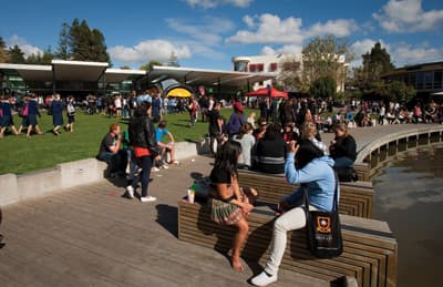 Studierende tummeln sich auf dem Campusgelände