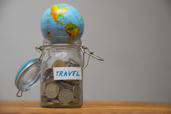 Einmachglas mit Geld und einer Miniatur-Weltkugel.