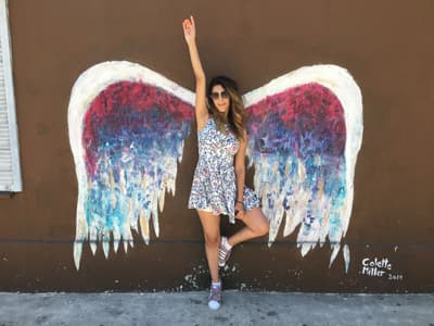 Mädchen vor Wand mit bemalten Flügeln