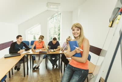 Studenten sitzen in einem Kursraum an einem Tisch