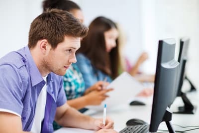 Ein Student sitzt konzentriert am Computer.