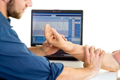 Techniker hilft bei der Anpassung und Benutzung einer Armprothese