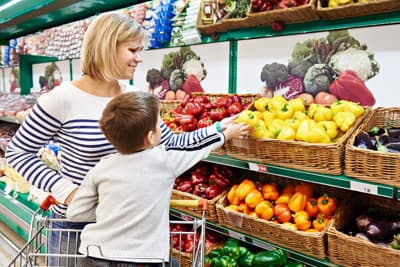 Mutter mit Kind beim Einkauf im Supermarkt