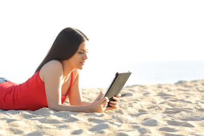 Junge Frau am Strand mit Tablet
