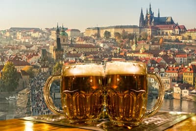 Zwei Biergläser vor Prager Kulisse