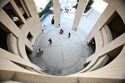 Ein Blick aus der Vogelperspektive auf eine ovale Halle mit Studierenden