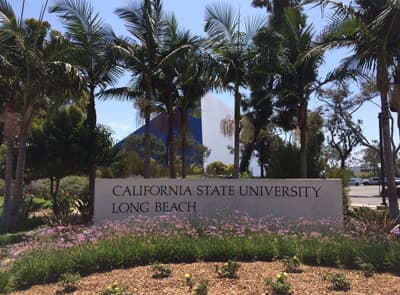Campus der California State University Long Beach mit Palmen und der der charakteristischen blauen Pyramide im Hintergrund