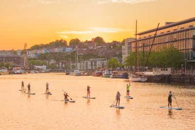 Standup-Paddler im Hafen von Bristol bei Sonnenuntergang