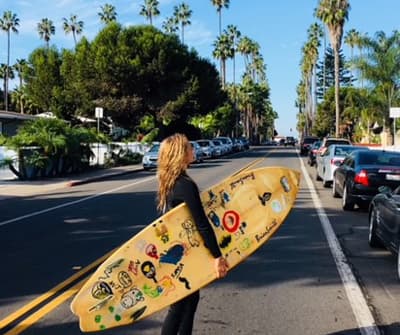 Studentin mit Surfbrett in San Diego